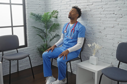 Nurse in blue scrubs sitting and resting between shifts in a hospital waiting area